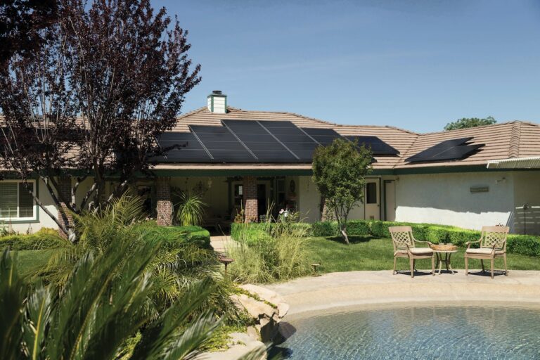 Casa com quintal grande e no telhado de casa há painéis de energia solar.