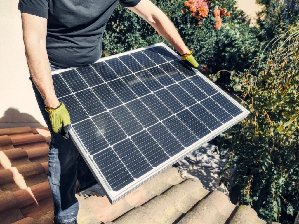 Homem instalando painel de energia solar